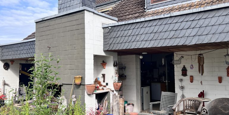 Rückseite mit Terrasse und Kamin