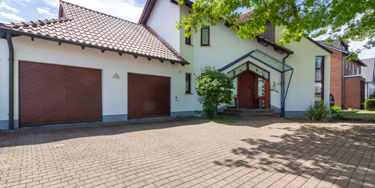 Großzügige Einfahrt, zwei Garagen und ein einladender Hauseingang – dieses Zuhause überzeugt schon beim ersten Eindruck.