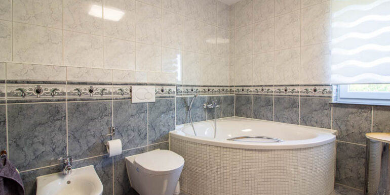 Helles Tageslichtbad mit stilvoller Eckwanne, Bidet und moderner Ausstattung – ein idealer Ort zum Entspannen.