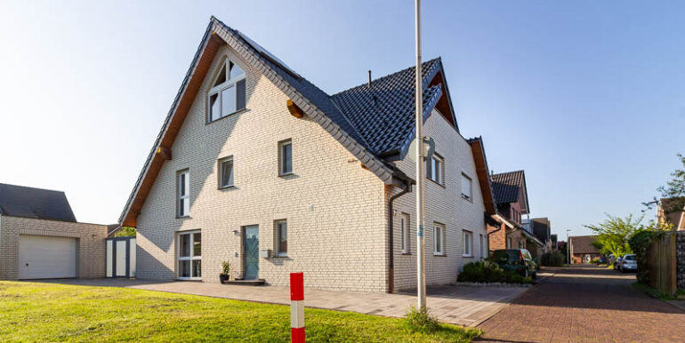 Repräsentative Doppelhaushälfte in moderner Klinkeroptik mit großer Einfahrt, Garage und gepflegtem Vorgarten – ein Zuhause mit Charakter.