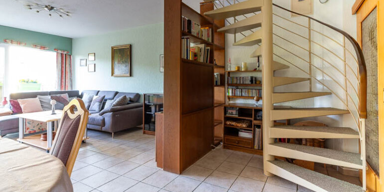 Elegante Wendeltreppe, die das offene Raumkonzept perfekt ergänzt und den Zugang zum Obergeschoss ermöglicht.