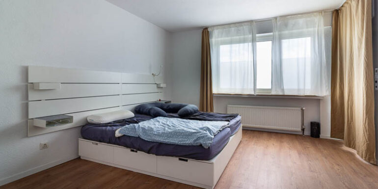 Ruhiges Schlafzimmer mit modernisierten Details und Balkonzugang.
