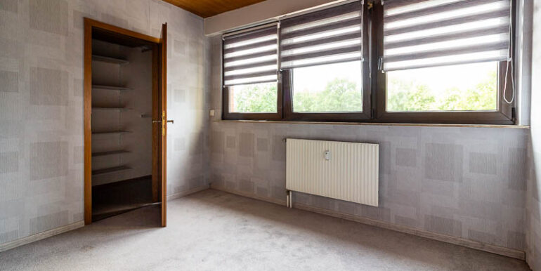 Helles Schlafzimmer mit praktischem Einbauschrank.