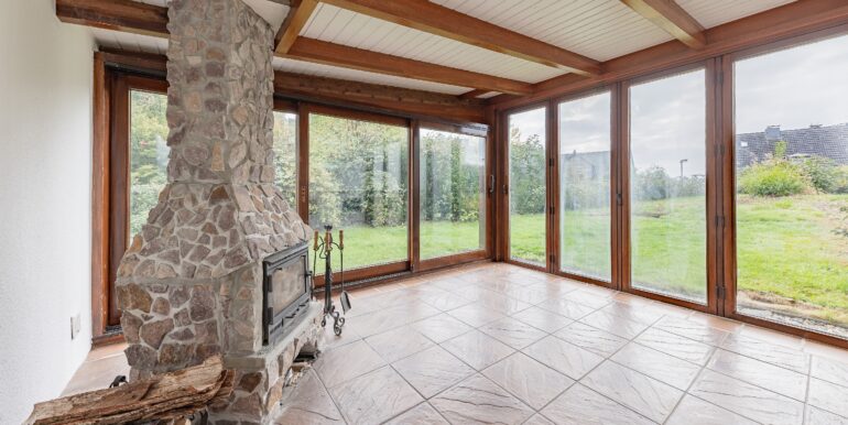 Wintergarten mit grüner Aussicht und Kamin