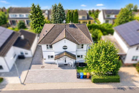 Sonniger Vorort mit weißem Traumhaus