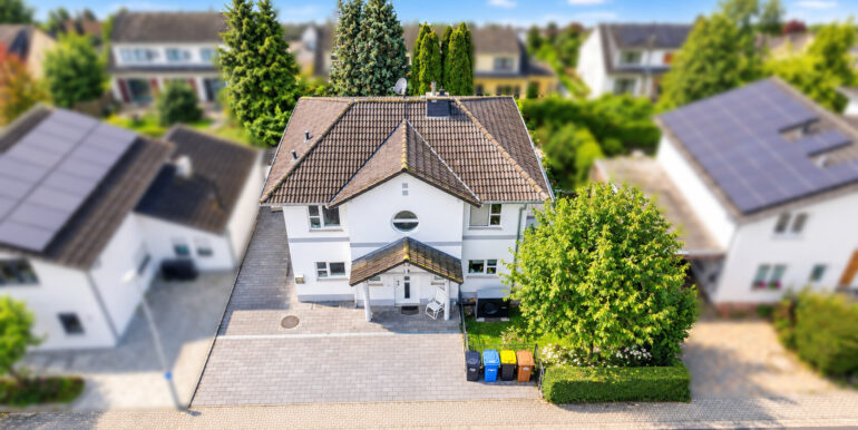 Sonniger Vorort mit weißem Traumhaus